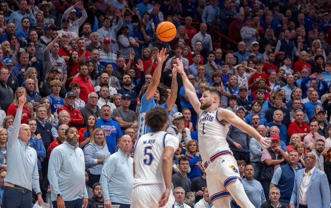 All eyes are on North Carolina guard Elliot Cadeau (3) as he launches a three-point basket at the buzzer under pressure from Kansas center Hunter Dickinson (1) on Friday, November 8, 2024 at Allen Fieldhouse in Lawrence, Kansas. Cadeau missed the shot to secure Kansas’ 92-89 victory.