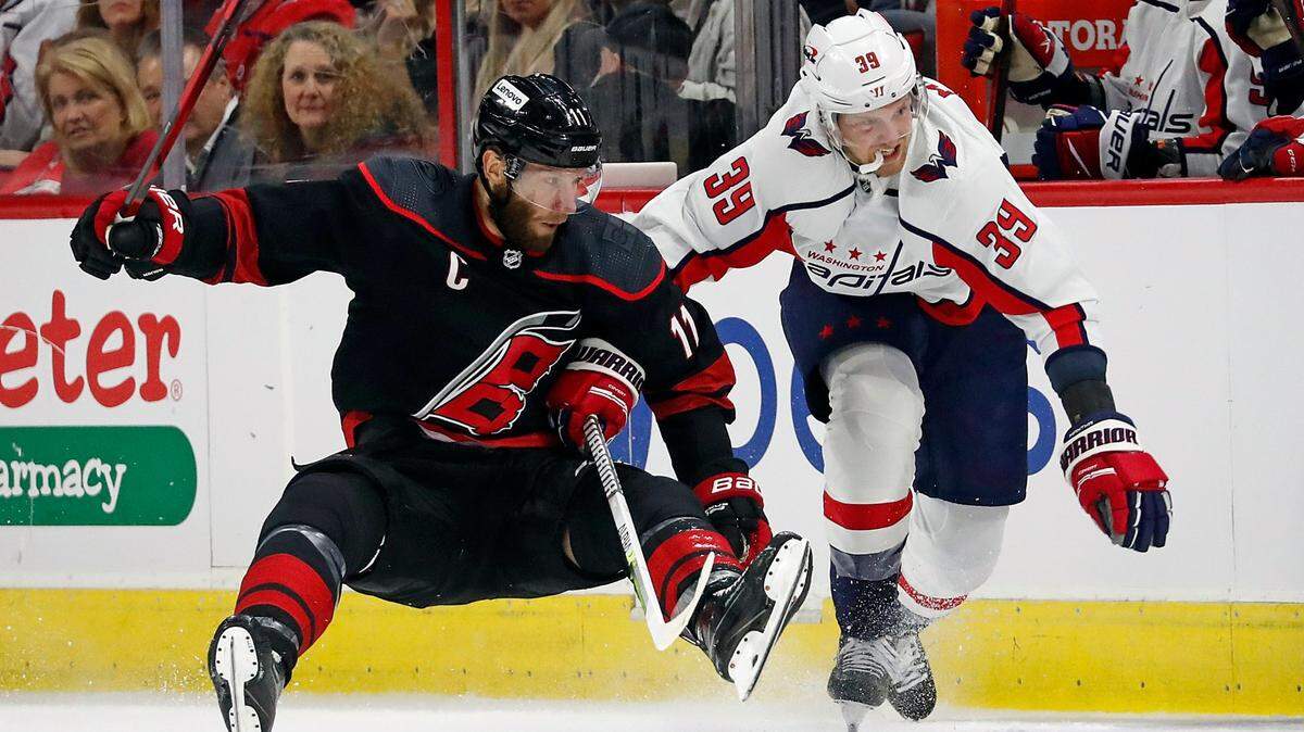Washington Capitals’ Anthony Mantha (39) takes Carolina Hurricanes’ Jordan Staal (11) off his skates during the first period of an NHL hockey game in Raleigh, N.C., Friday, March 18, 2022. (AP Photo/Karl B DeBlaker)