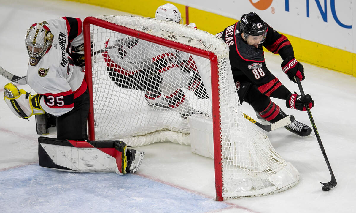 Ottawa’s Austin Watson (16) works to stop Carolina’s Hurricanes’ Martin Necas (88) as he moves the puck behind the Ottawa goal in overtime on Tuesday, April 4, 2023 at PNC Arena in Raleigh, N.C.
