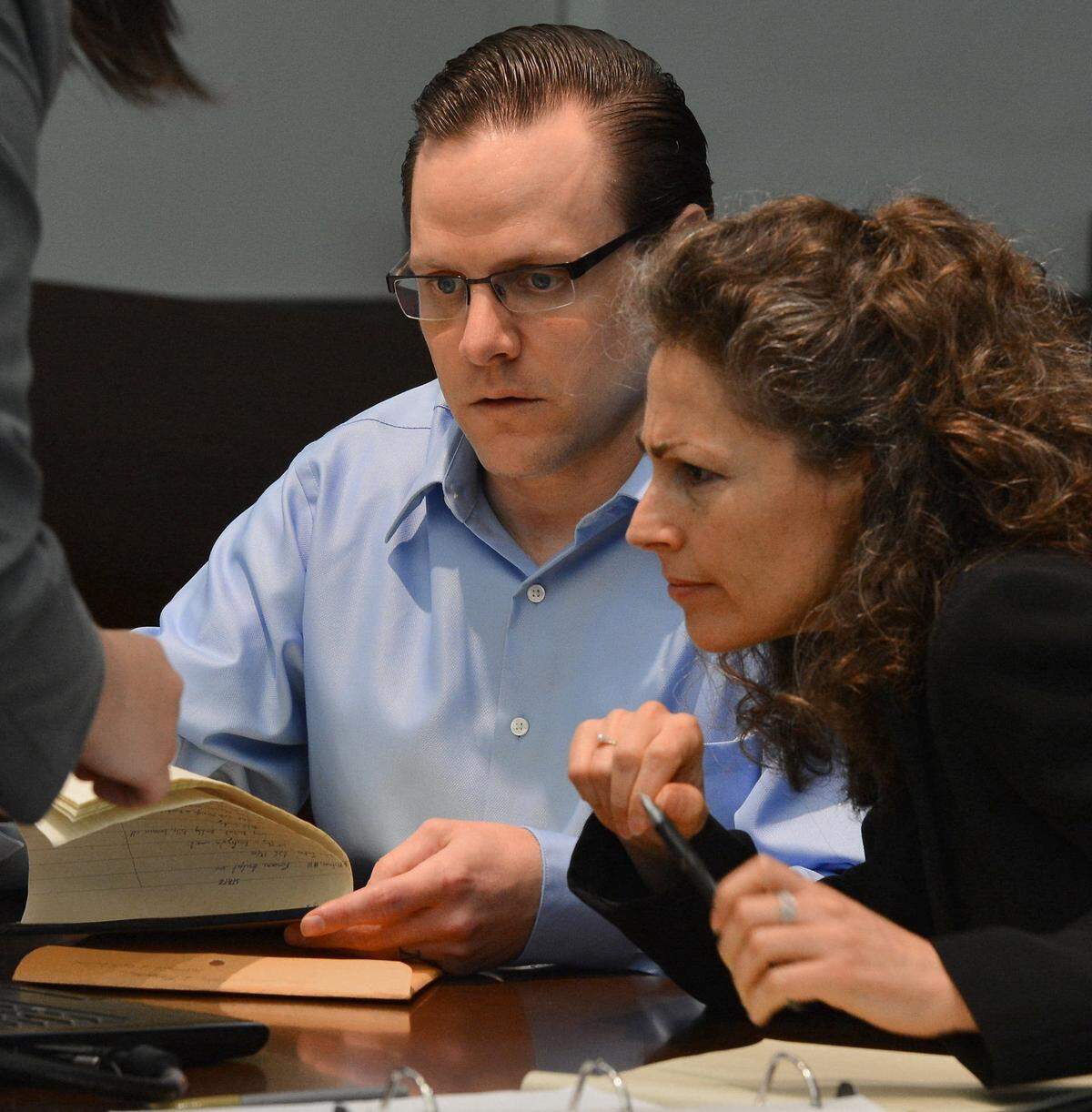 Raven Abaroa looks at photos on a computer with attorney Mani Dexter during his 2013 murder trial. Abaroa is accused of stabbing his wife Janet Marie Christiansen Abaroa to death in 2005.