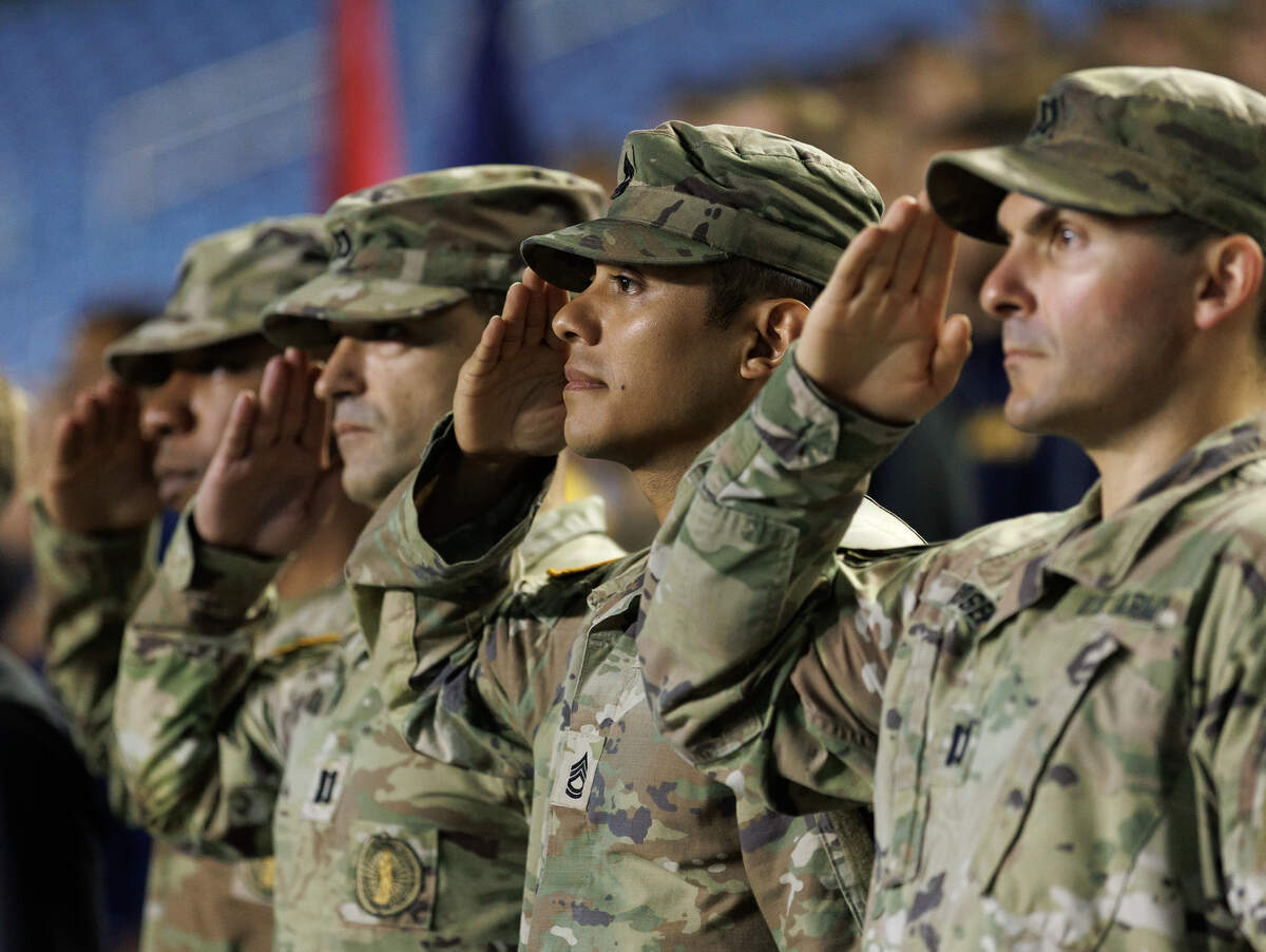 People salute as the national anthem is sung during an event at Kenan Memorial Stadium in Chapel Hill, N.C. on Thursday, Sept. 11, 2025, to honor those who lost their lives during the attacks of Sept. 11, 2001.
