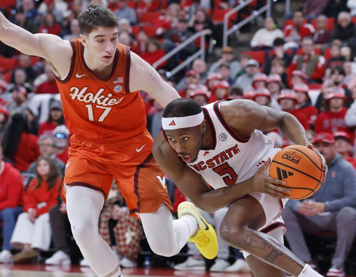 N.C. State’s Tre Holloman drives past Virginia Tech’s Neoklis Avdalas during the first half of the Wolfpack’s game on Saturday, Feb. 7, 2026 at Lenovo Center in Raleigh, N.C. 