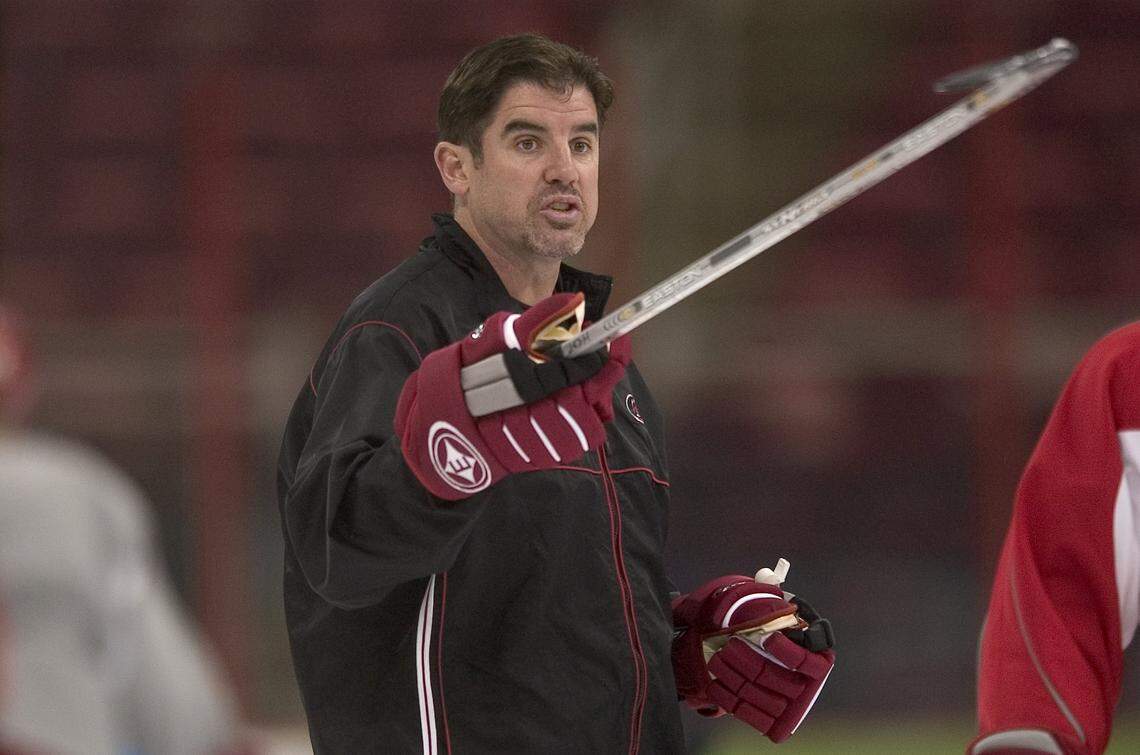 With a hockey stick and a whistle in his hands, then-Carolina Hurricanes head coach Peter Laviolette directs his team during a 2006 practice session.