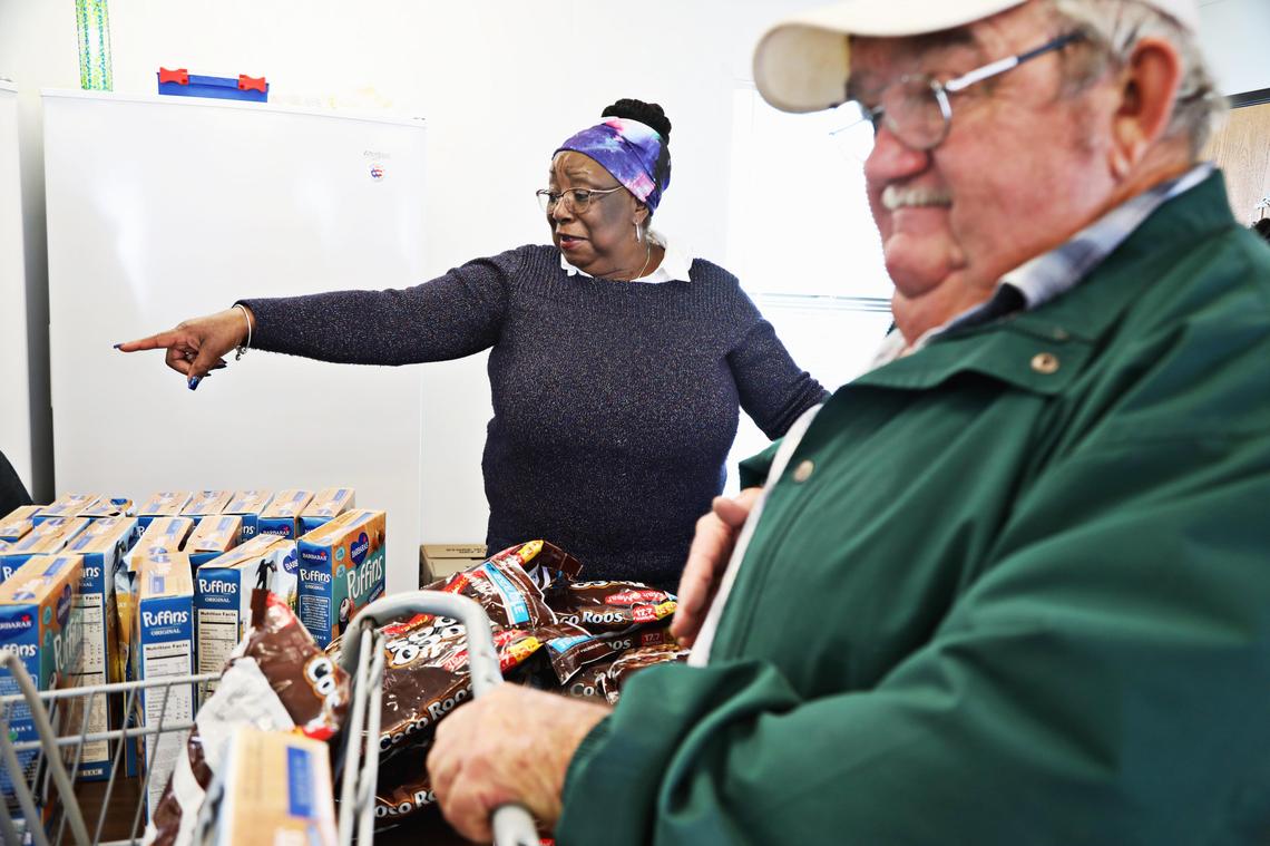 Rebecca Baines Cisse, left, who manages the Disaster Recovery Food Pantry in Trenton, directs client Haywood Jones, right, to the next table as he picks up food Tuesday morning, Nov. 26, 2019. Food insecurity in the greater New Bern area post-Florence has increased as the area continues to struggle in its recovery.