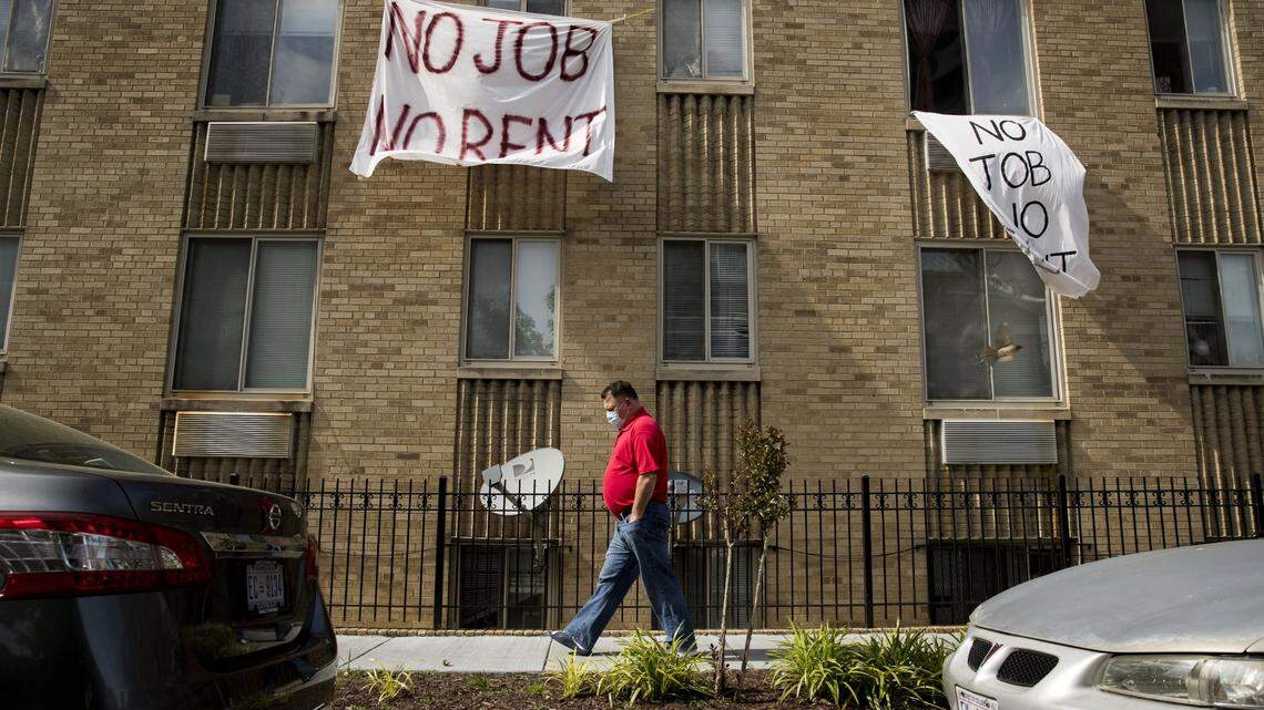 Signs that read “No Job No Rent” hang from the windows of an apartment building in Northwest Washington, Wednesday, May 20, 2020.