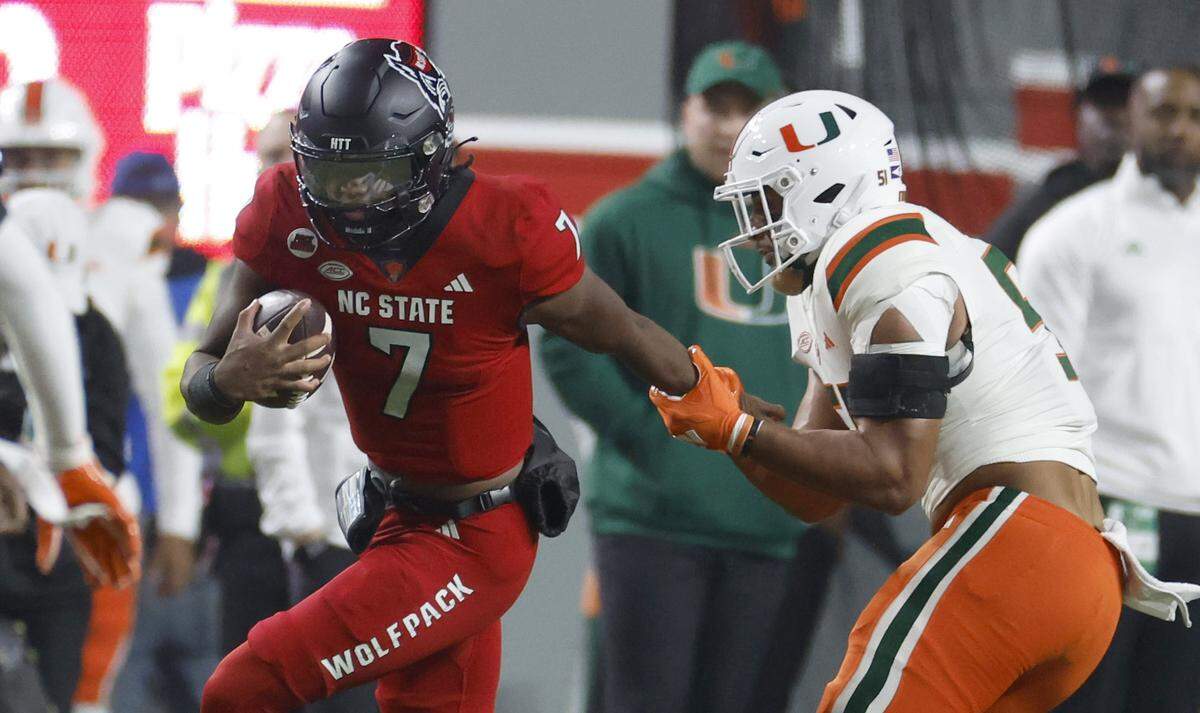 Miami linebacker Francisco Mauigoa (51) stops N.C. State quarterback MJ Morris (7) on a run during the first half of N.C. State’s game against Miami at Carter-Finley Stadium in Raleigh, N.C., Saturday, Nov. 4, 2023.