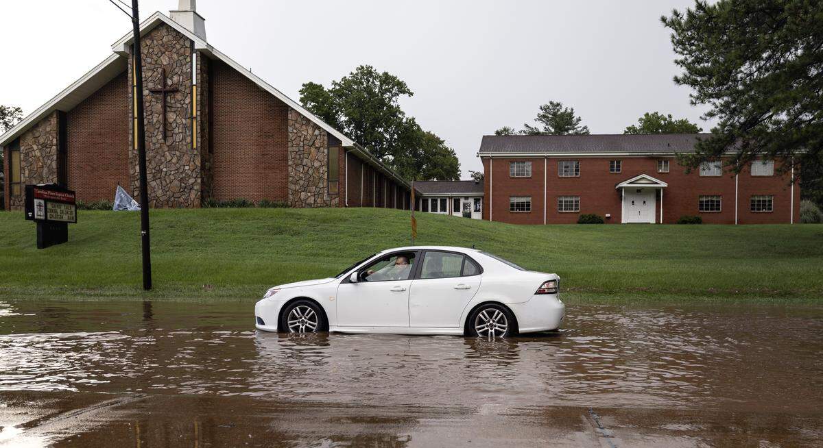 A car sits stalled in a flooded S. Saunders Street after heavy rains in Raleigh, N.C., Sunday, August 4, 2024.