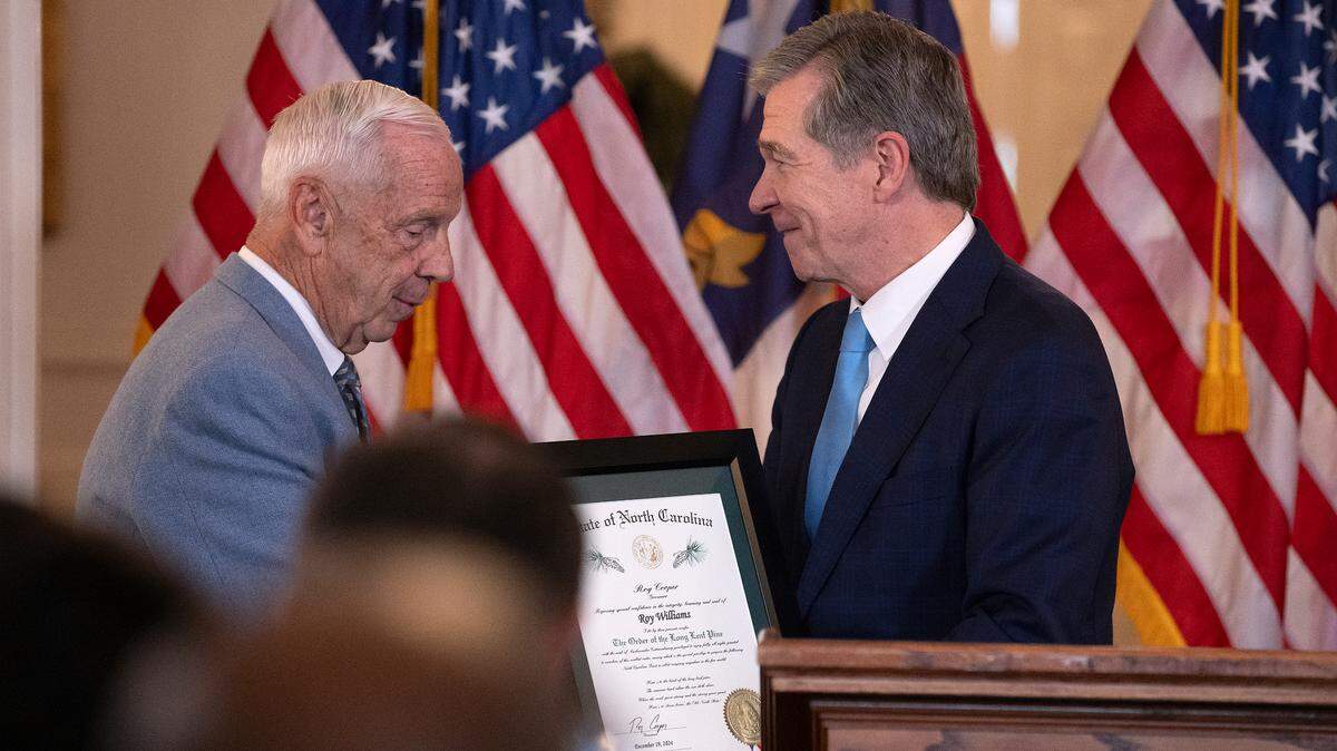 Gov. Roy Cooper presents The Order of the Long Leaf Pine to former North Carolina basketball coach Roy Williams during a ceremony at the Executive Mansion on Thursday, Dec. 19, 2024, in Raleigh, N.C.