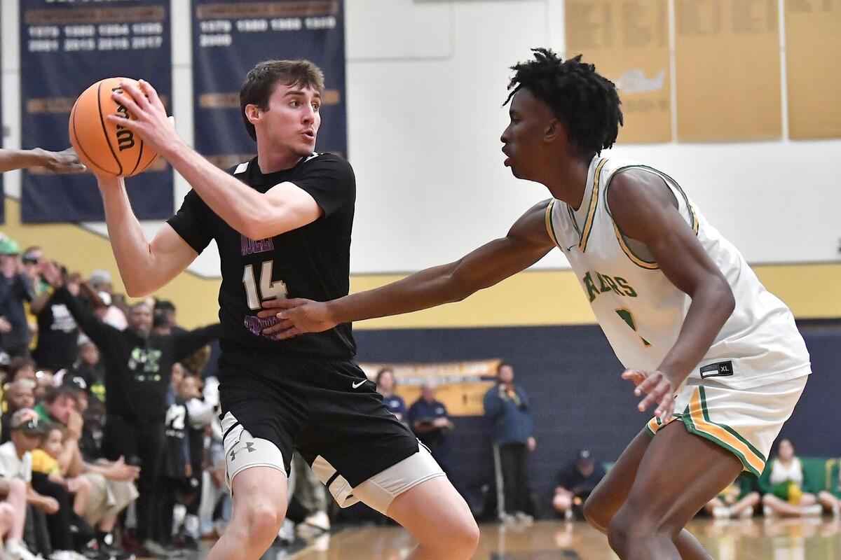 Holly Springs’ Houston Wills (14) looks to pass against Richmond’s Paul McNeil (2) during the second half. The Richmond Raiders and the Holly Springs Golden Hawks met in the NCHSAA 4A East Regional Finals in Sanford, N.C. on March 4, 2023.