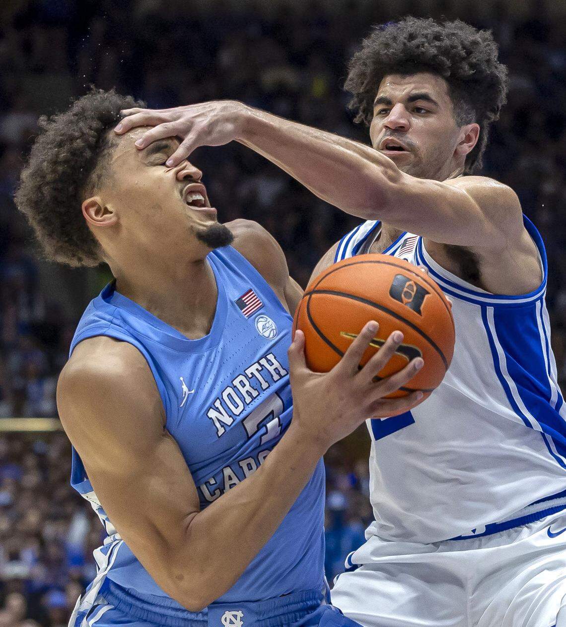 Duke guard Cayden Boozer (2) pokes North Carolina guard Seth Trimble (7) in the eye during the second half on Saturday, March 7, 2026 at Cameron Indoor Stadium in Durham, N.C.