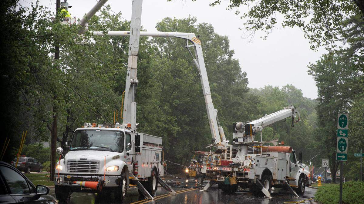 Duke Energy works on a fallen power line near the intersection of Downey Court and Glen Eden Drive in Raleigh, N.C., on July 8, 2021.