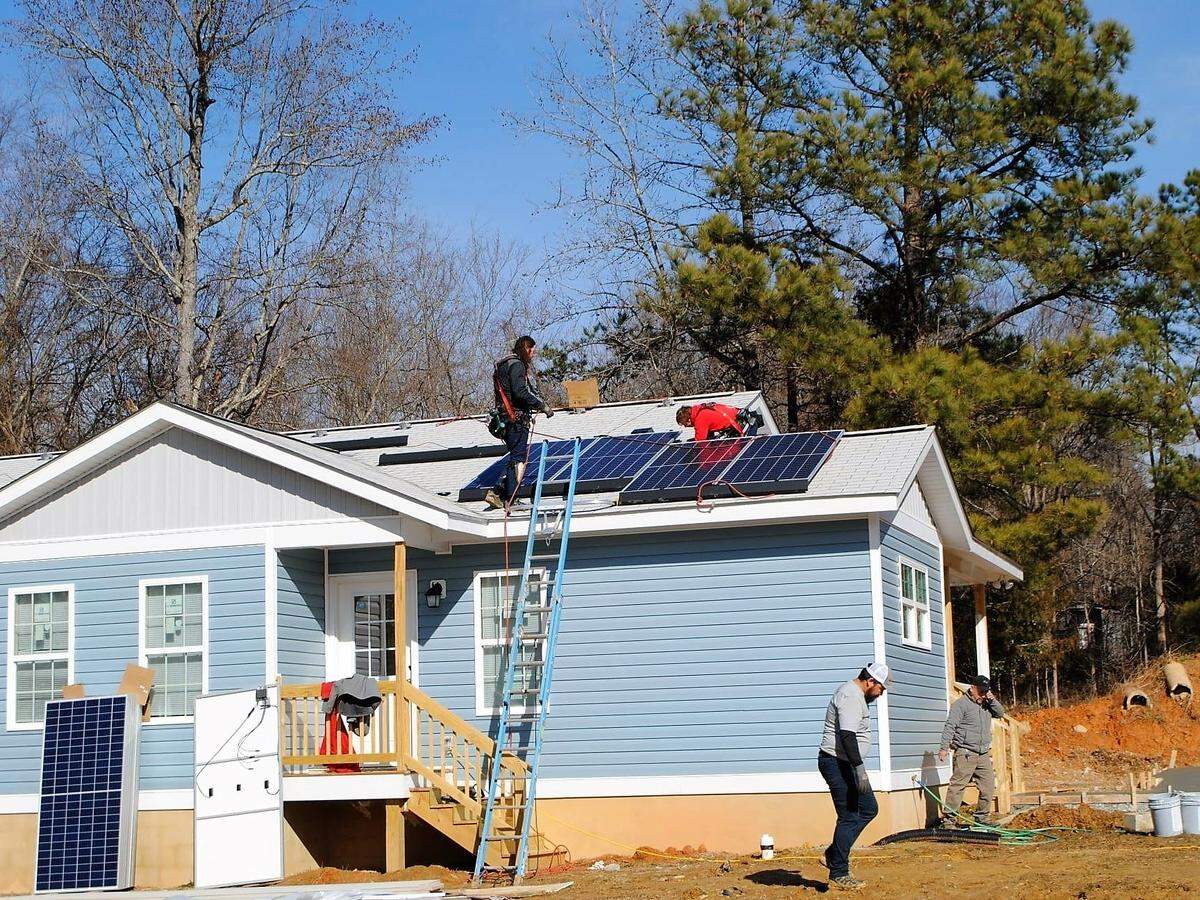 Habitat for Humanity volunteers install solar panels on a new home in Orange County. The nonprofit housing agency received a $100,000 county climate action grant in 2023 to add solar panels to 14 new homes in Chapel Hill and Hillsborough.