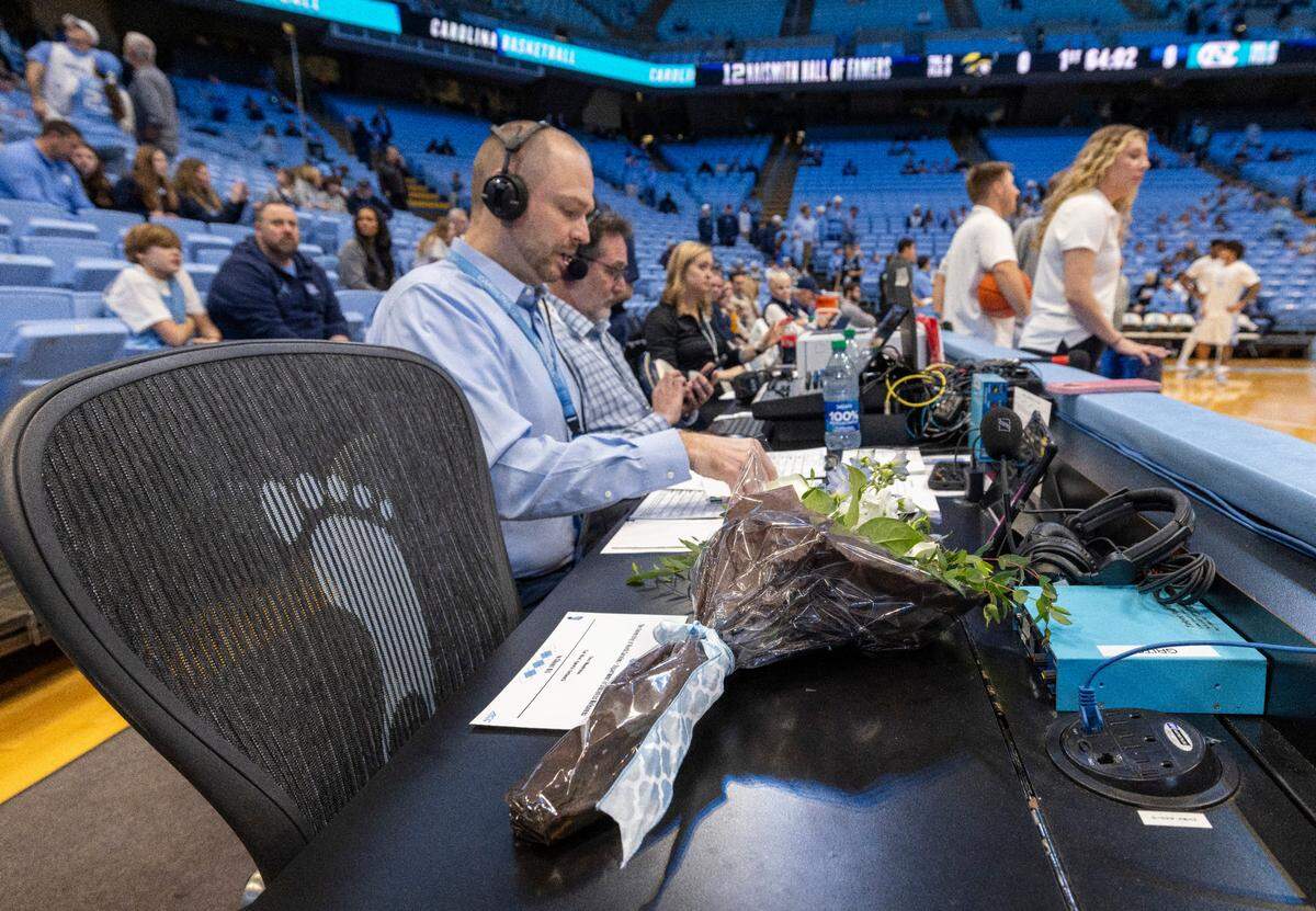 A memorial for former North Carolina player Eric Montross and is set up court side beside radio announcer Jones Angell, prior to the Tar Heels’ game against Charleston Southern on Friday, December 29, 2023 at the Smith Center in. Chapel Hill, N.C. Montross who died of cancer on December 17, 2023 was the color commentator for the Tar Heel Sports Network.