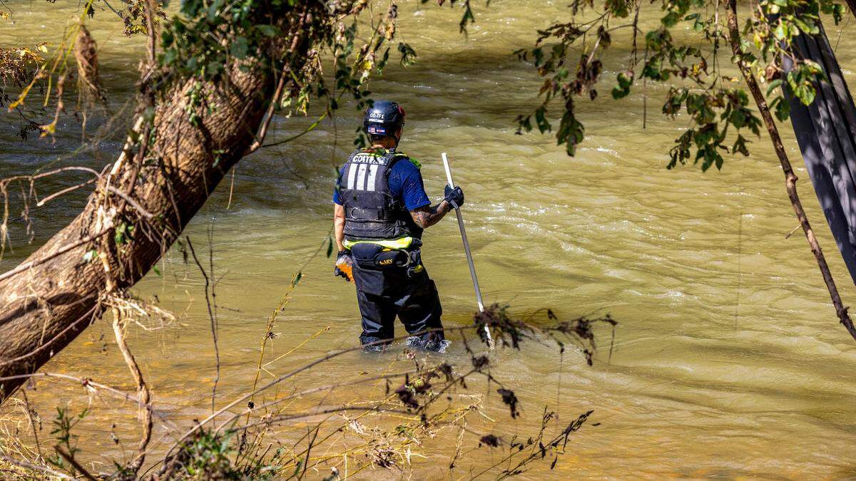 A member of a search and rescue team from Colorado wades into the Catawba River searching for victims of Hurricane Helene on Wednesday, October 2, 2024 near Old Fort, N.C.