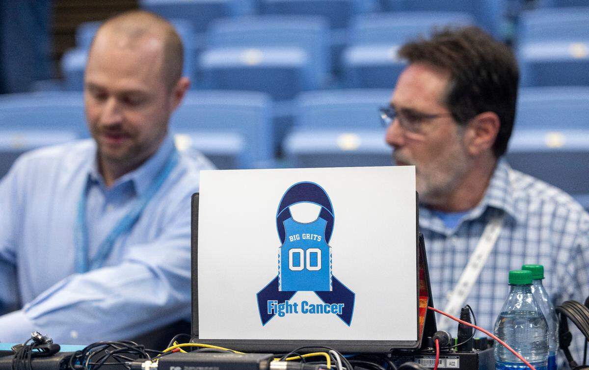 A memorial for former North Carolina player Eric Montross and is set up court side beside radio announcer Jones Angell, prior to the Tar Heels’ game against Charleston Southern on Friday, December 29, 2023 at the Smith Center in Chapel Hill, N.C. Montross who died of cancer on December 17, 2023 was the color commentator for the Tar Heel Sports Network.