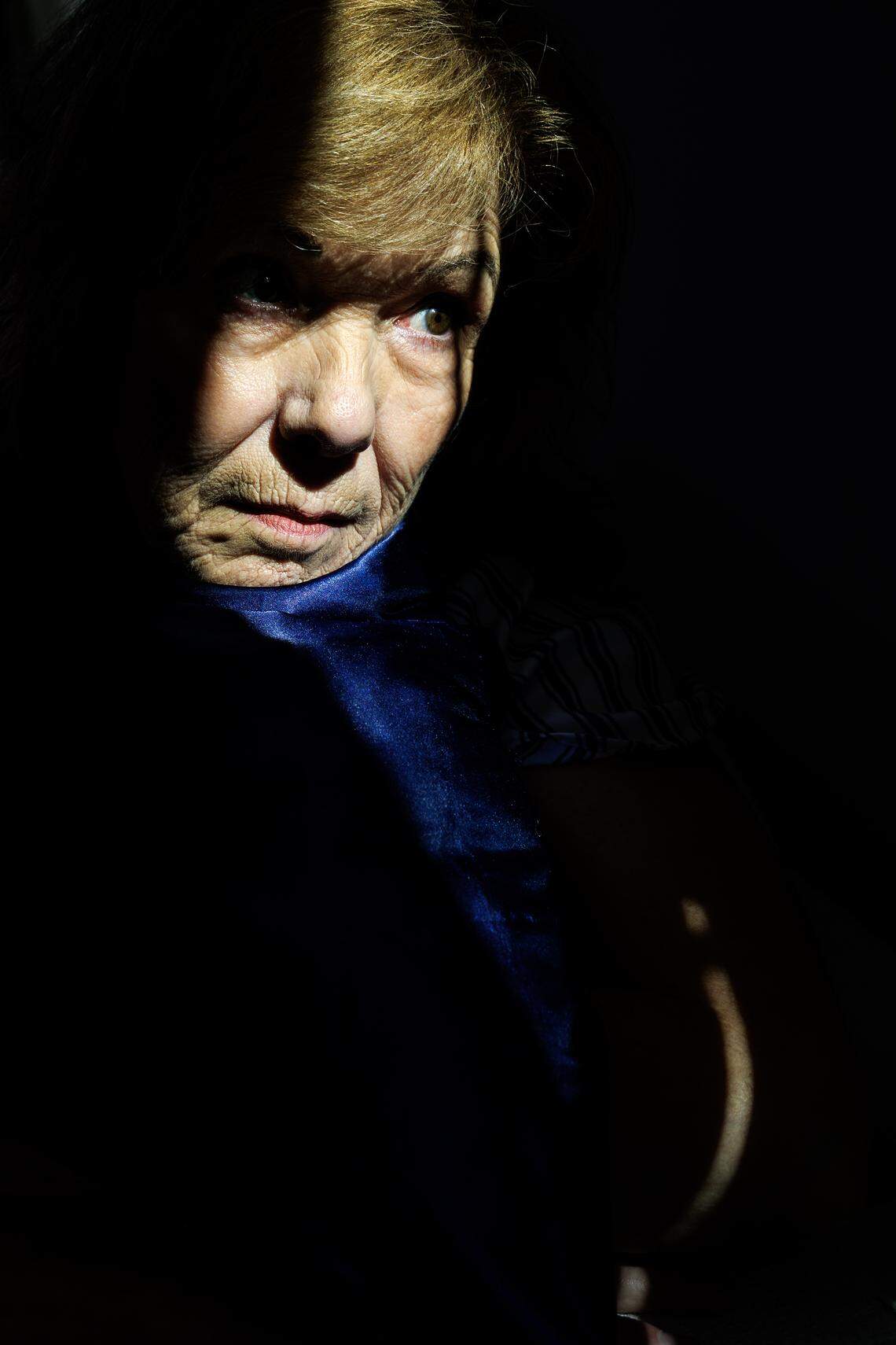 Jill Rohner holds a pillow that belonged to her partner, John, as she sits in her new home on Tuesday, Oct. 7, 2025. John was fatally shot by her ex-husband, against whom she had a domestic violence protective order, in late January.