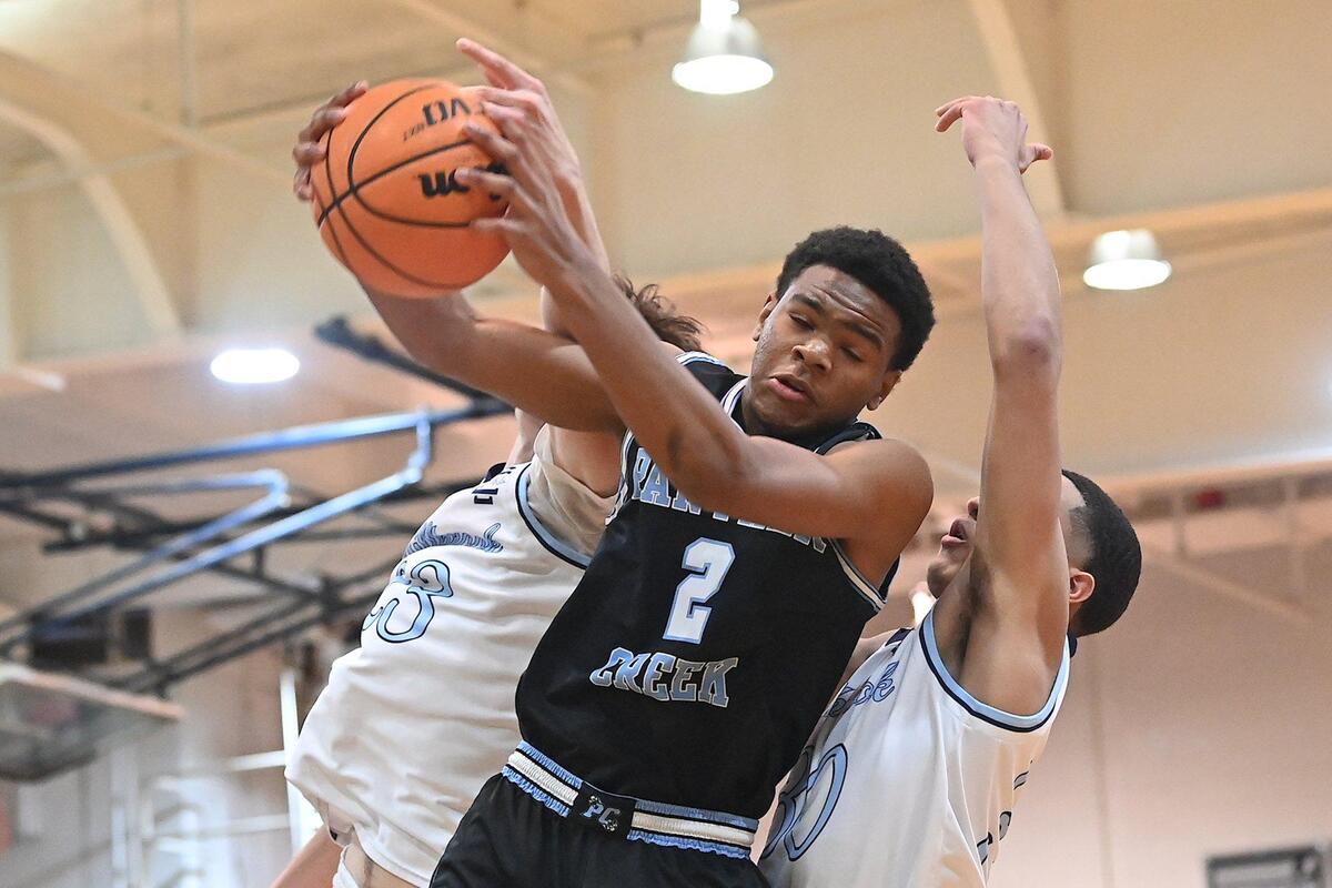 Panther Creek’s Amari Odom (2) controls the rebound against Millbrook’s Colt Langdon (23) and Gabriel Cerda (30) in the first half. The Millbrook Wildcats and the Panther Creek Catamounts met in a NCHSAA 4A fourth round game in Raleigh, N.C. on March 1, 2022.