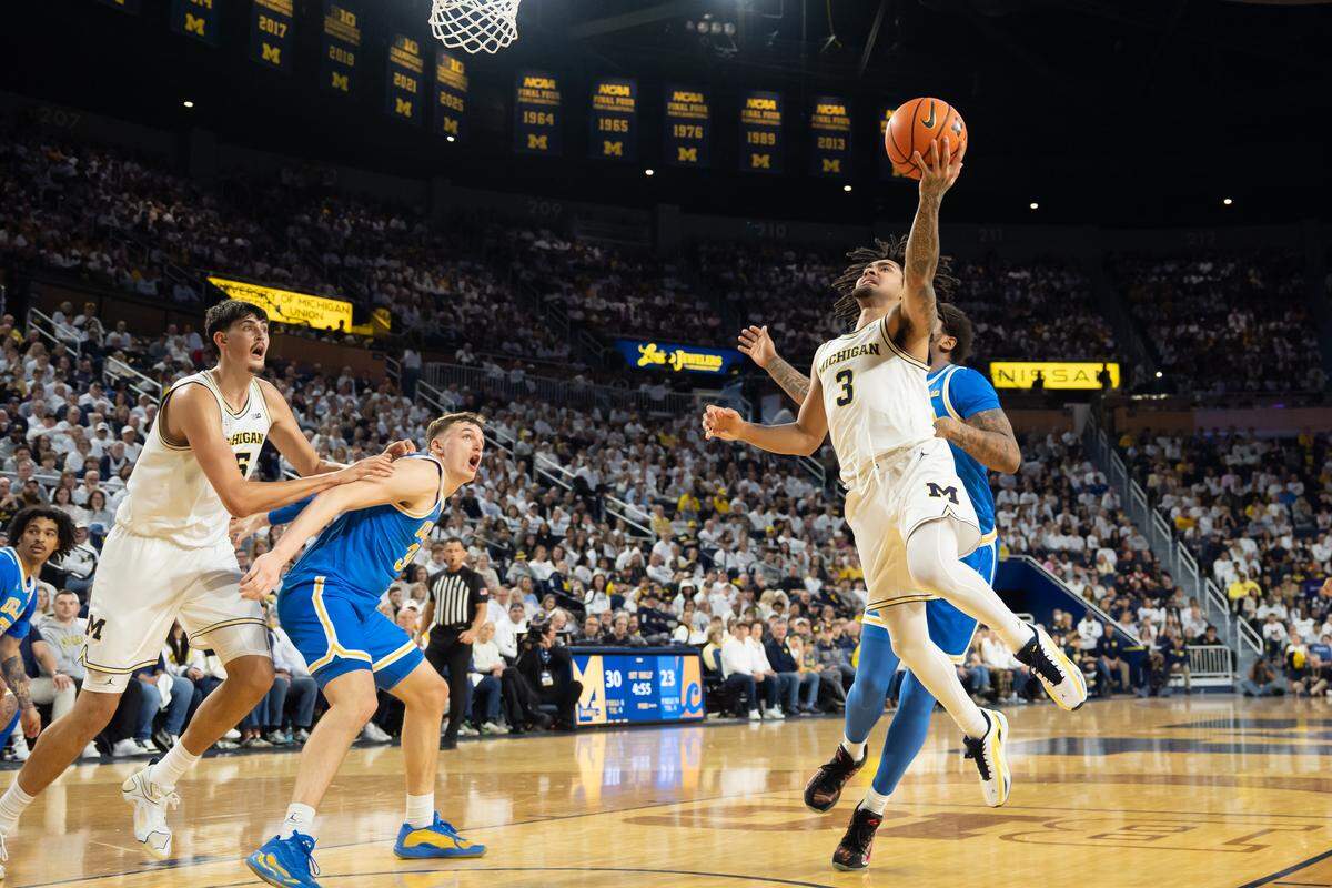 Elliot Cadeau (3) of the Michigan Wolverines drives to the basket during the first half against the UCLA Bruins at Crisler Arena on Feb. 14, 2026 in Ann Arbor, Michigan.