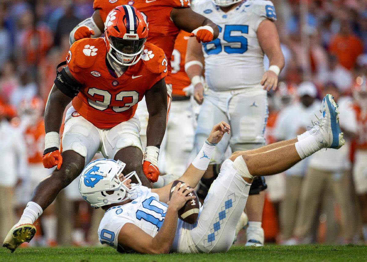 North Carolina quarterback Drake Maye (10) goes down after being sacked by Clemson’s T.J. Parker (12) for an eight-yard loss in the second quarter on Saturday, November 18, 2023 at Memorial Stadium in Clemson, S.C.