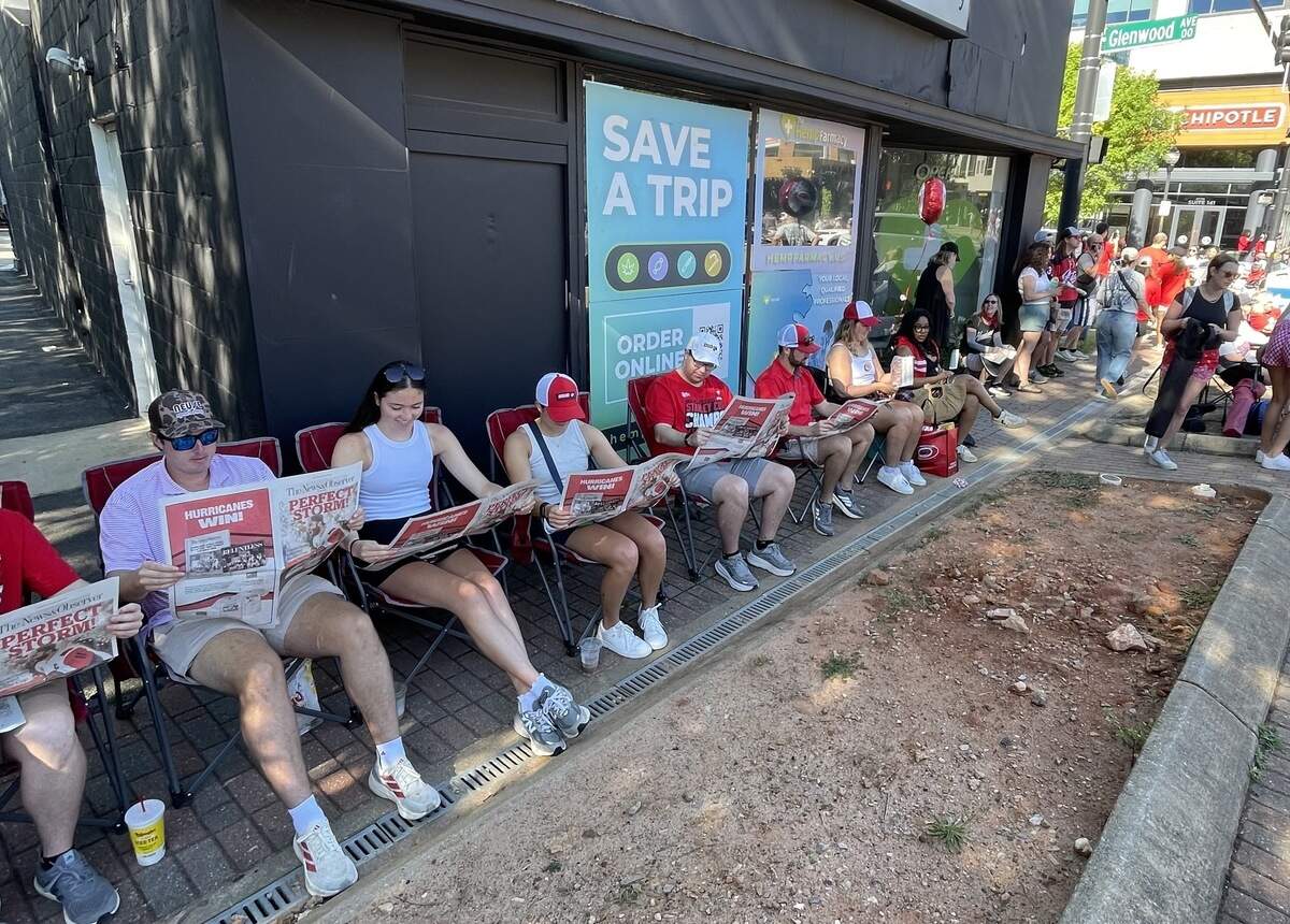 Fans line Fayetteville Street reading News & Observer special editions on the Hurricanes’ Stanley Cup win.