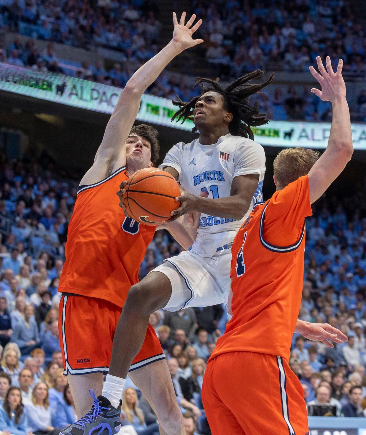North Carolina guard Ian Jackson (11) drives to the basket against Virginia’s Blake Buchanan (0) and Andrew Rohde (4) in the first half on Saturday, February 22, 2025 at the Smith Center in Chapel Hill, N.C.