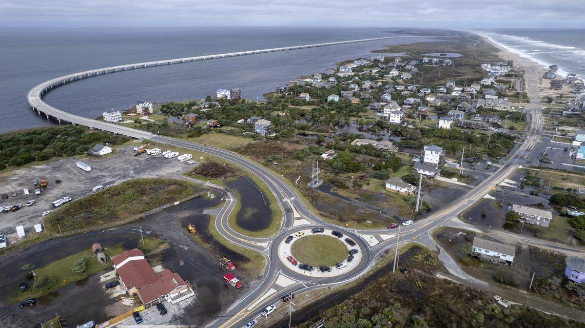 Motorists park on the inside of the roundabout south of the Jug Handle Bridge in Rodanthe while waiting for N.C. Highway 12 to reopen on Monday, Oct. 13, 2025, as NCDOT crews work to clear sand and overwash deposited on the road during a nor’easter.