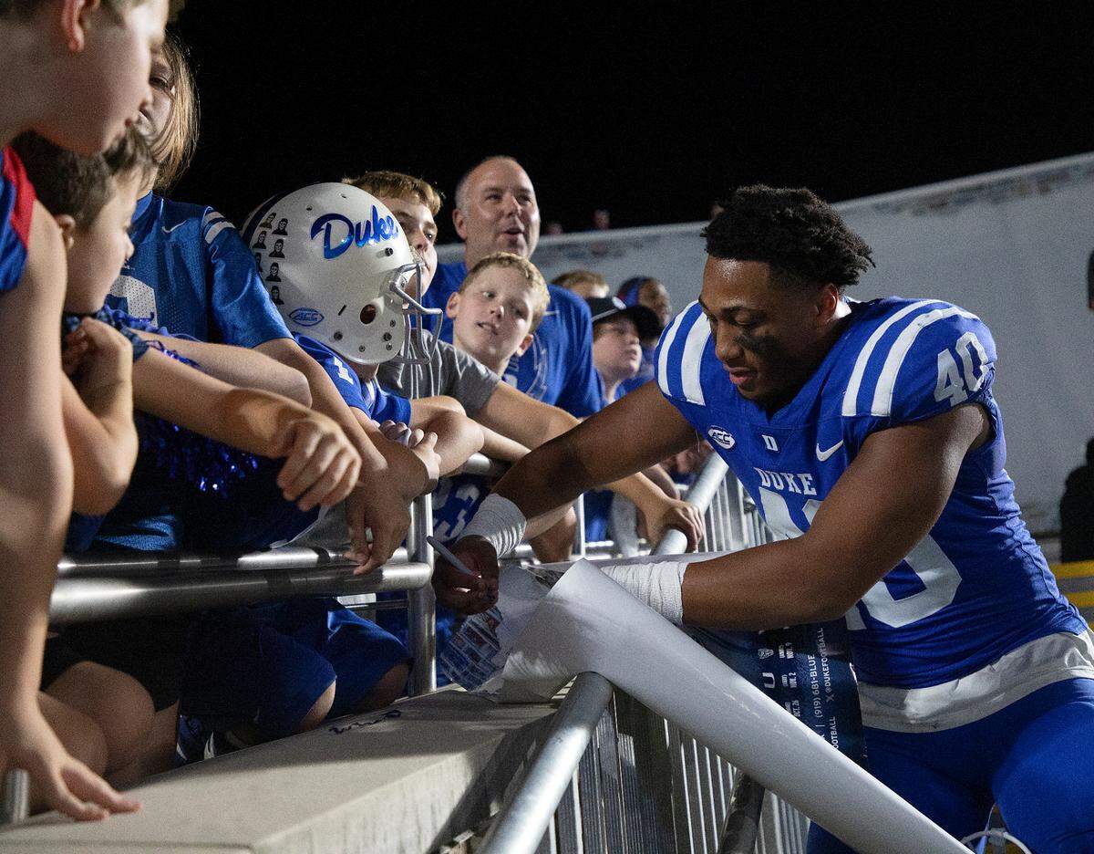 Duke’s Ryan Smith signs autographs for fans following the Blue Devils’ 26-21 win over UConn on Saturday, Sept. 14, 2024, at Wallace Wade Stadium in Durham, N.C.