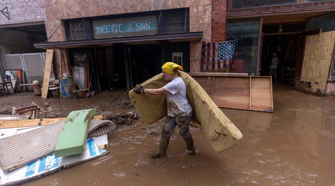 Kelley Greene of Marshall helps clean up downtown on Tuesday, Oct. 1, 2024 after the French Broad River caused catastrophic flooding. The remnants of Hurricane Helene caused widespread flooding, downed trees, and power outages in western North Carolina.
