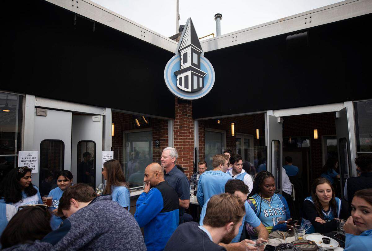 A crowd of mostly UNC fans gather on the balcony at Top of the Hill in Chapel Hill, N.C. to watch their team face off with their rival, Duke, in New Orleans in a historic Final Four game on Saturday, April 2, 2022.