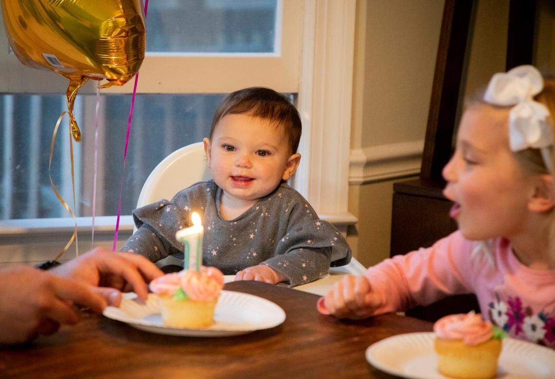 Lily Casadonte watches as her sister Lucy blows out the candle on the cupcakes bought to celebrate her first birthday, which falls on the day before the anniversary of North CarolinaÕs first public case of COVID-19, on Tuesday, Mar. 2, 2021, in Cary, N.C.