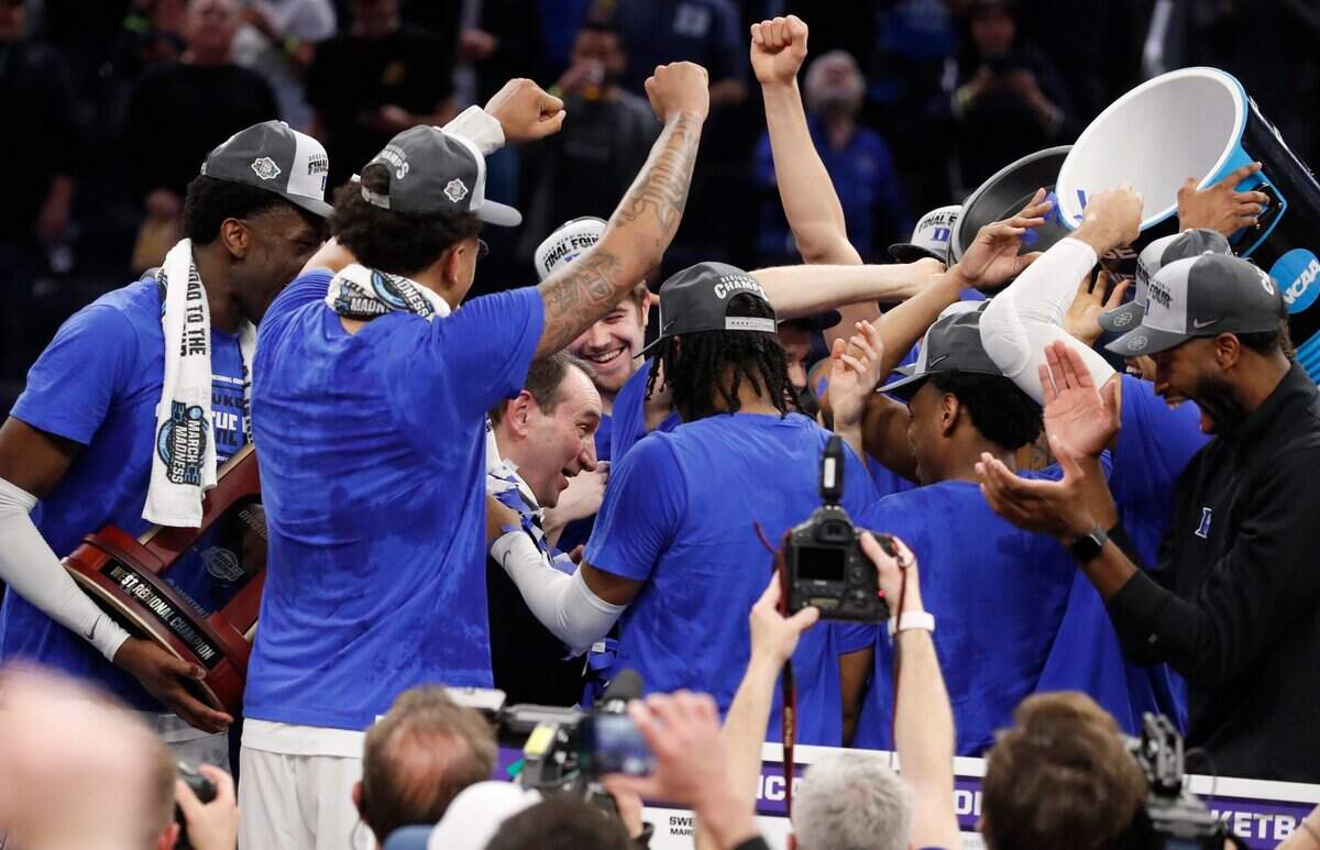 Duke head coach Mike Krzyzewski is surrounded by his players after Dukes 78-69 victory over Arkansas in the NCAA Tournament West Regional finals at the Chase Center in San Francisco, Calif., Saturday, March 26, 2022.