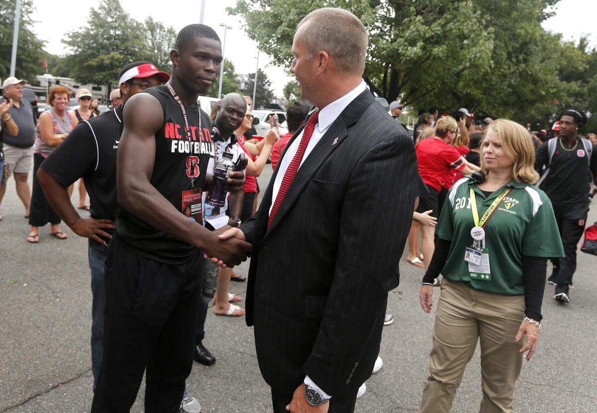 N.C. State head football coach greets signee Kelvin Harmon during the Walk of Champions before the Wolfpack’s game against Eastern Kentucky at Carter-Finley Stadium in Raleigh, N.C., Saturday, Sept. 12, 2015.