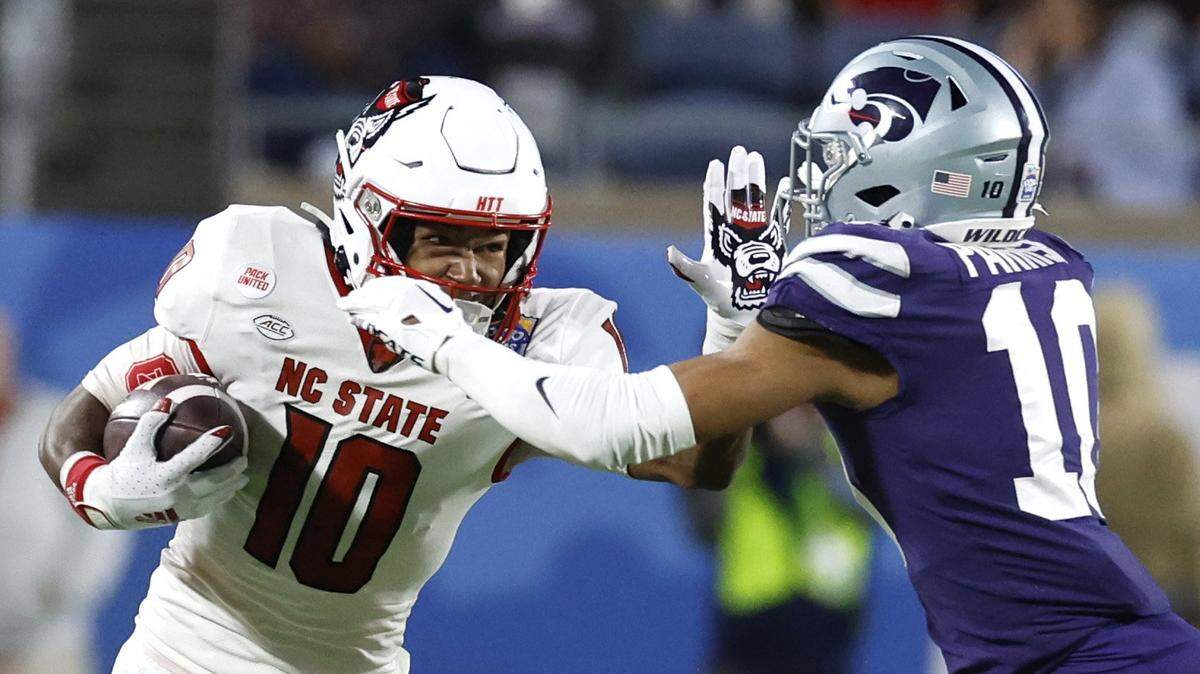 N.C. State wide receiver KC Concepcion (10) stiff-arms Kansas State cornerback Jacob Parrish (10) during the first half of N.C. State’s game against Kansas State in the Pop-Tarts Bowl at Camping World Stadium in Orlando, Fla., Thursday, Dec. 28, 2023.