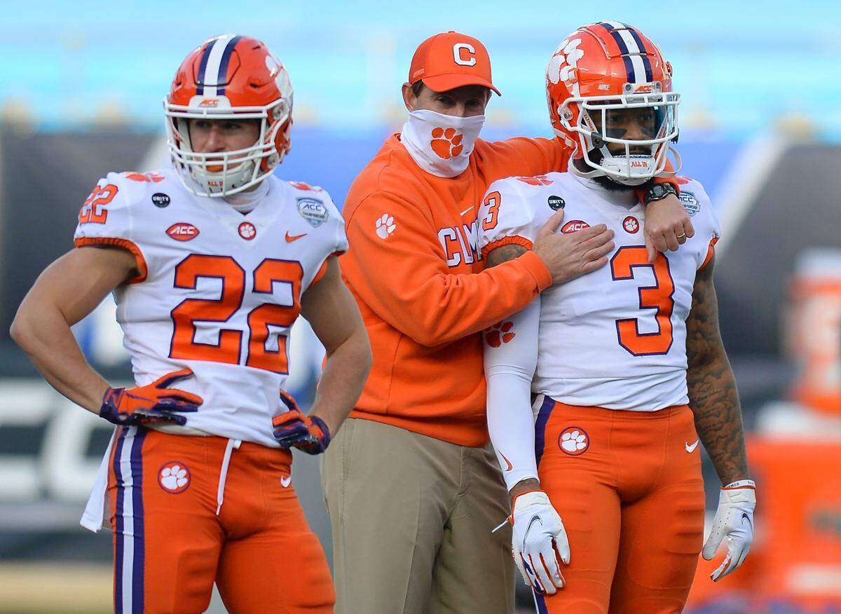 Clemson Tigers head coach Dabo Swinney, center, hugs wide receiver Amari Rodgers, right, during a warmup at Bank of America Stadium on Saturday, December 19, 2020 in Charlotte, NC. The Clemson Tigers face the Notre Dame Fighting Irish in the ACC Championship game.