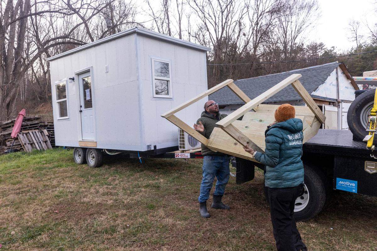 Co-directors of the nonprofit BeLoved Asheville, “Ponkho” Bermejo, left, and Amy Cantrell, help set up a tiny home for a resident in Leicester on Thursday, Dec. 5, 2024. From supplying meals to paying rent, Beloved Asheville has been helping to support Western North Carolina residents impacted by the remnants of Hurricane Helene.
