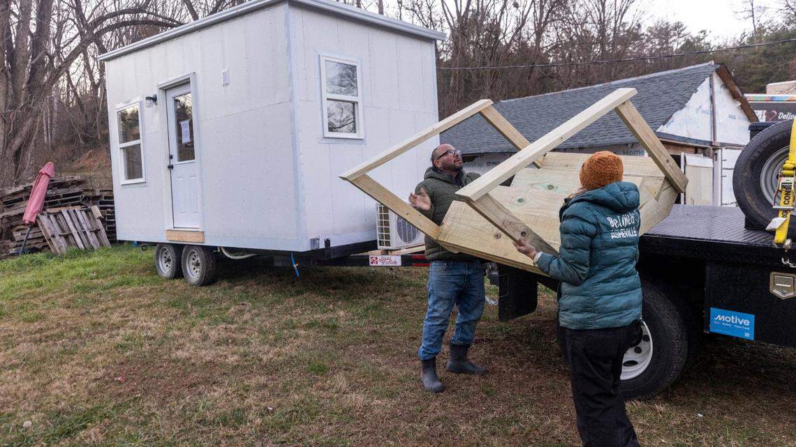 Co-directors of the nonprofit BeLoved Asheville, “Ponkho” Bermejo, left, and Amy Cantrell, help set up a tiny home for a resident in Leicester in December.