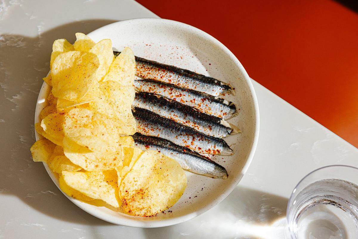 A classic Spanish tapas dish, boquerones or cured Spanish anchovies, is served with potato chips at Proximo.