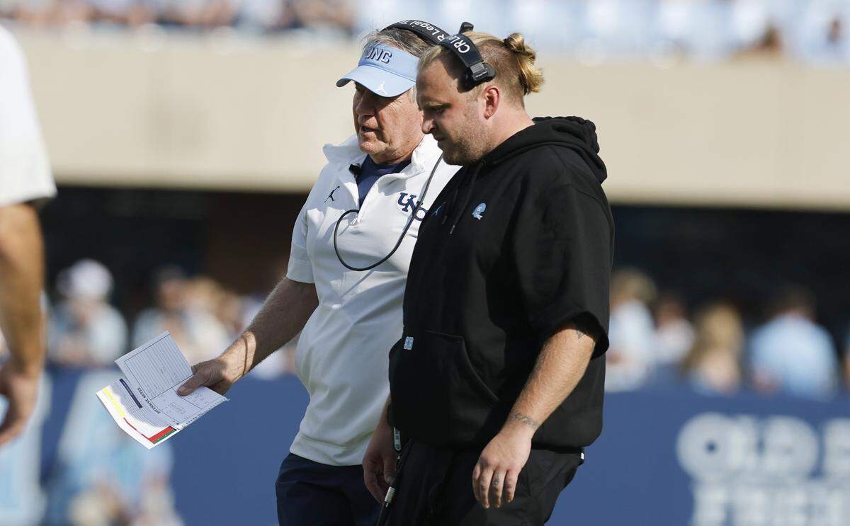 North Carolina head coach Bill Belichick talks to his son, defensive coordinator Steve Belichick during the Tar Heels’ win over the Spiders on Saturday. 