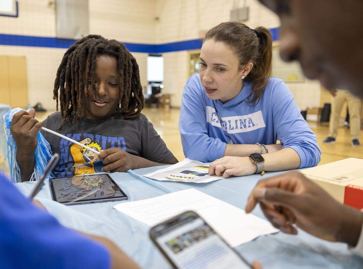 Ragan Copeland, director of community engagement for the UNC basketball team, works with Cameron Kelley and players as they design t-shirts for Black History Month at the Hargraves Community Center on Wednesday, January 7, 2026 in Chapel Hill, N.C.  