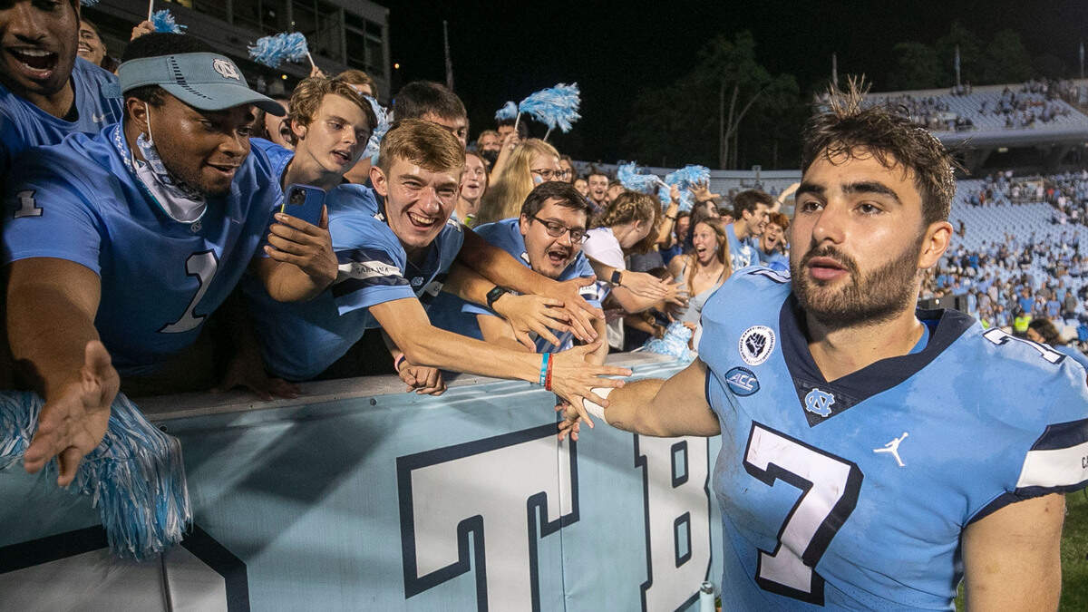 North Carolina quarterback Sam Howell (7) celebrates the Tar Heels’ 59-39 victory over Virginia with the student section on Saturday, September 18, 2021 at Kenan Stadium in Chapel Hill, N.C. Howell threw for 307 yards and five touchdowns in the Tar Heels’ 59-39 victory.