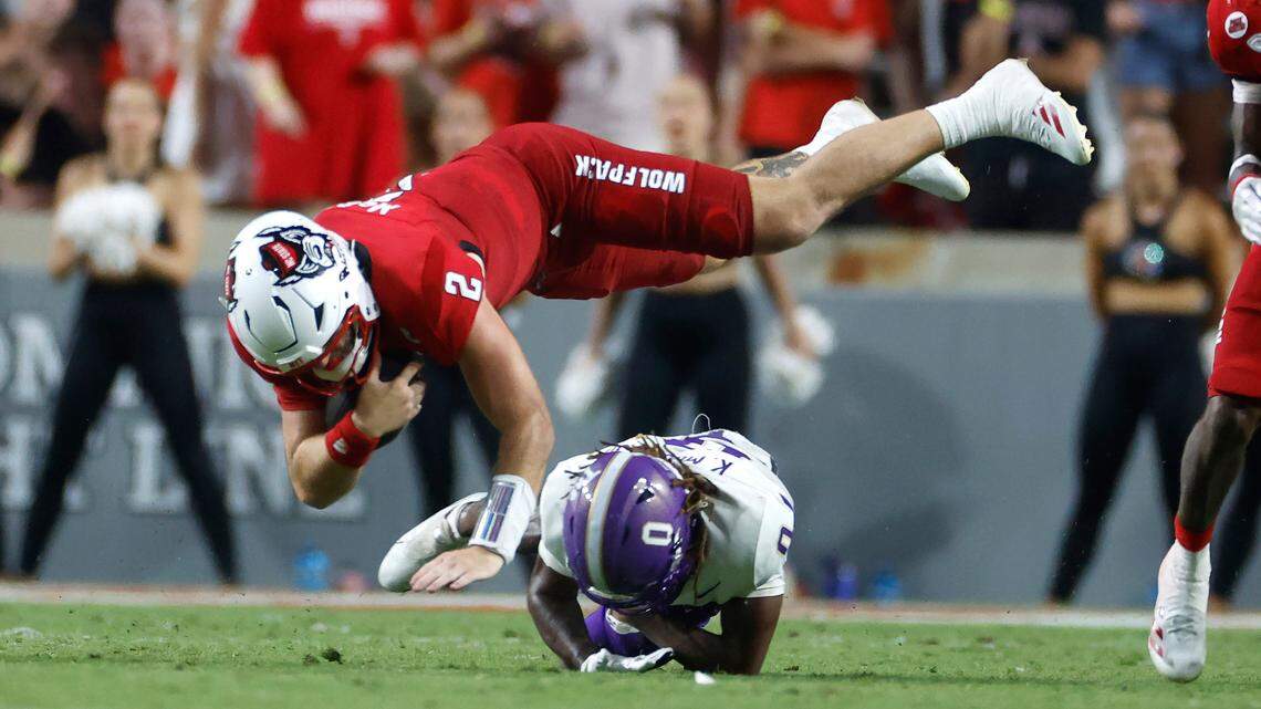 N.C. State quarterback Grayson McCall (2) dives over Western Carolina cornerback Ken Moore Jr. (0) during the second half of N.C. State’s 38-21 victory over Western Carolina at Carter-Finley Stadium in Raleigh, N.C., Thursday, August 29, 2024.