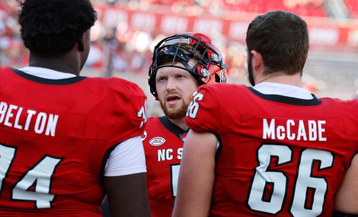 N.C. State quarterback Brennan Armstrong (5) talks with offensive lineman Anthony Belton (74) and Matt McCabe (66) during the second half of the Wolfpack’s 45-7 victory over VMI at Carter-Finley Stadium in Raleigh, N.C., Saturday, Sept. 16, 2023.