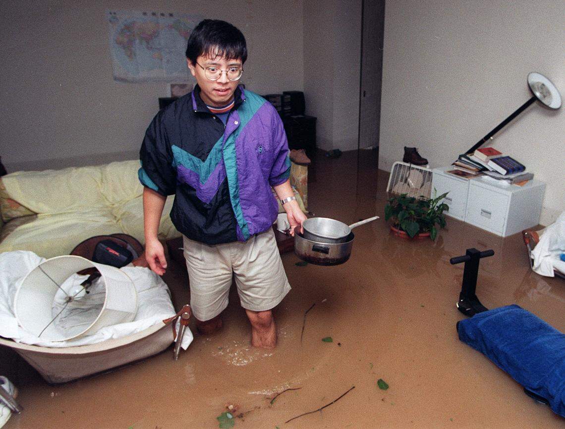 A shocked Song Qian wades through his flooded apartment at Kensington Park Apartments after it flooded as Hurricane Fran passed through.  He was not sure where the pots and pans came from. They were not his.  