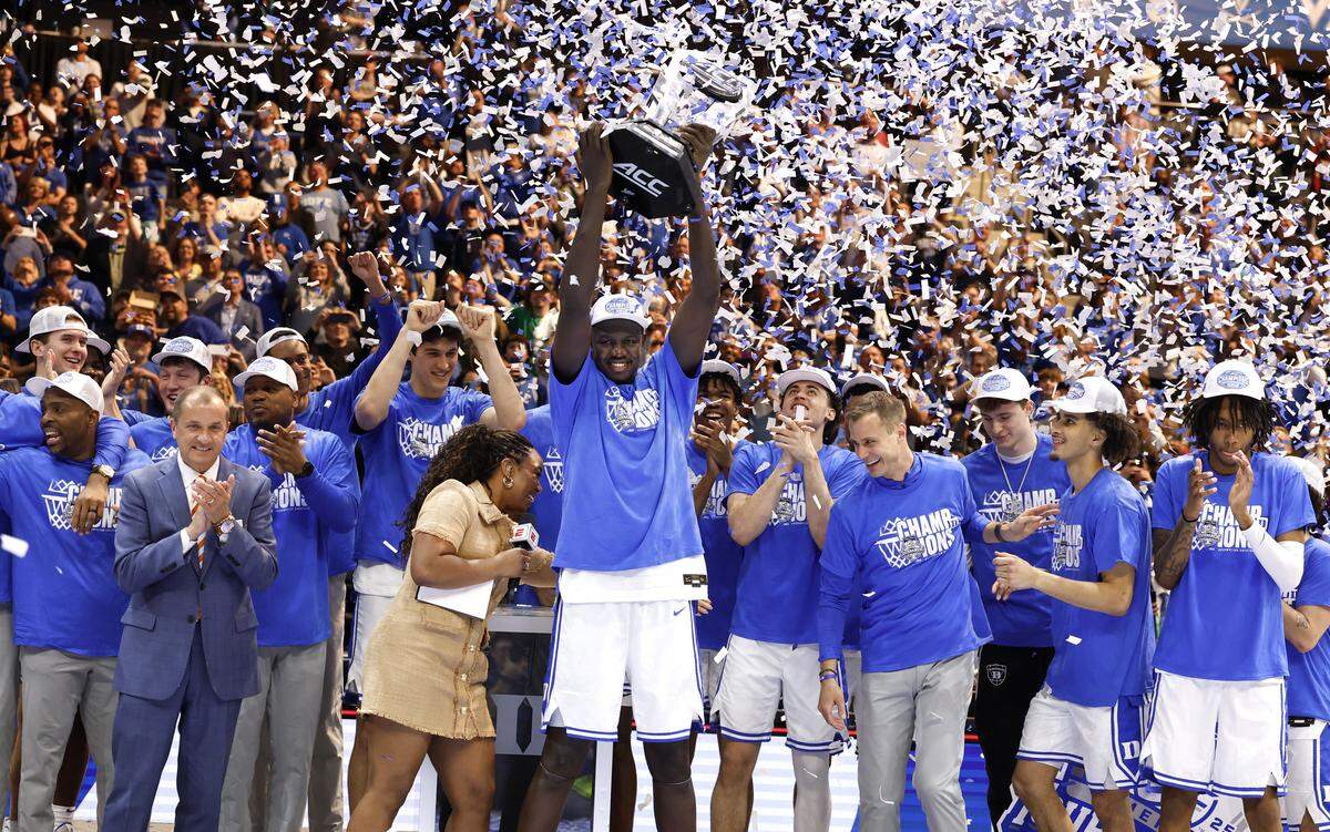 Duke’s Khaman Maluach (9) holds up the championship trophy after Duke’s 73-62 victory over Louisville in the finals of the 2025 ACC Men’s Basketball Tournament at the Spectrum Center in Charlotte, N.C., Saturday, March 15, 2025.