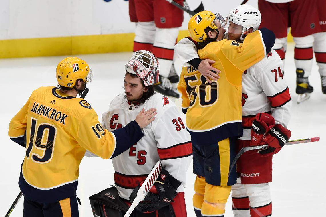 Nashville Predators center Calle Jarnkrok (19) and Carolina Hurricanes goaltender Alex Nedeljkovic (39) greet each other as Erik Haula (56) and Jaccob Slavin (74) hug after the Hurricanes defeated the Predators in overtime of Game 6 of an NHL hockey Stanley Cup first-round playoff series Thursday, May 27, 2021, in Nashville, Tenn. The Hurricanes advanced to the second round. (AP Photo/Mark Zaleski)