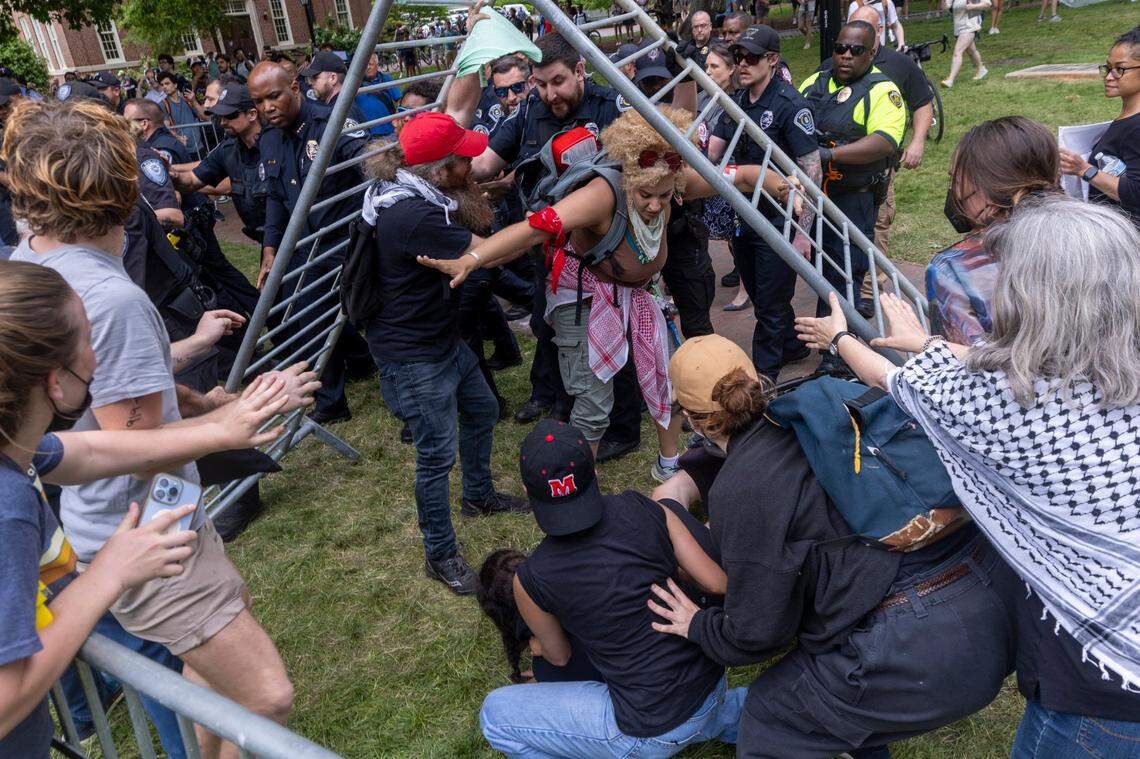 A Pro-Palestinian demonstrator is knocked from a wheelchair as demonstrators clash with police after replacing an American flag with a Palestinian flag Tuesday, April 30, 2024 at UNC-Chapel Hill. Police removed a “Gaza solidarity encampment” earlier Tuesday morning.