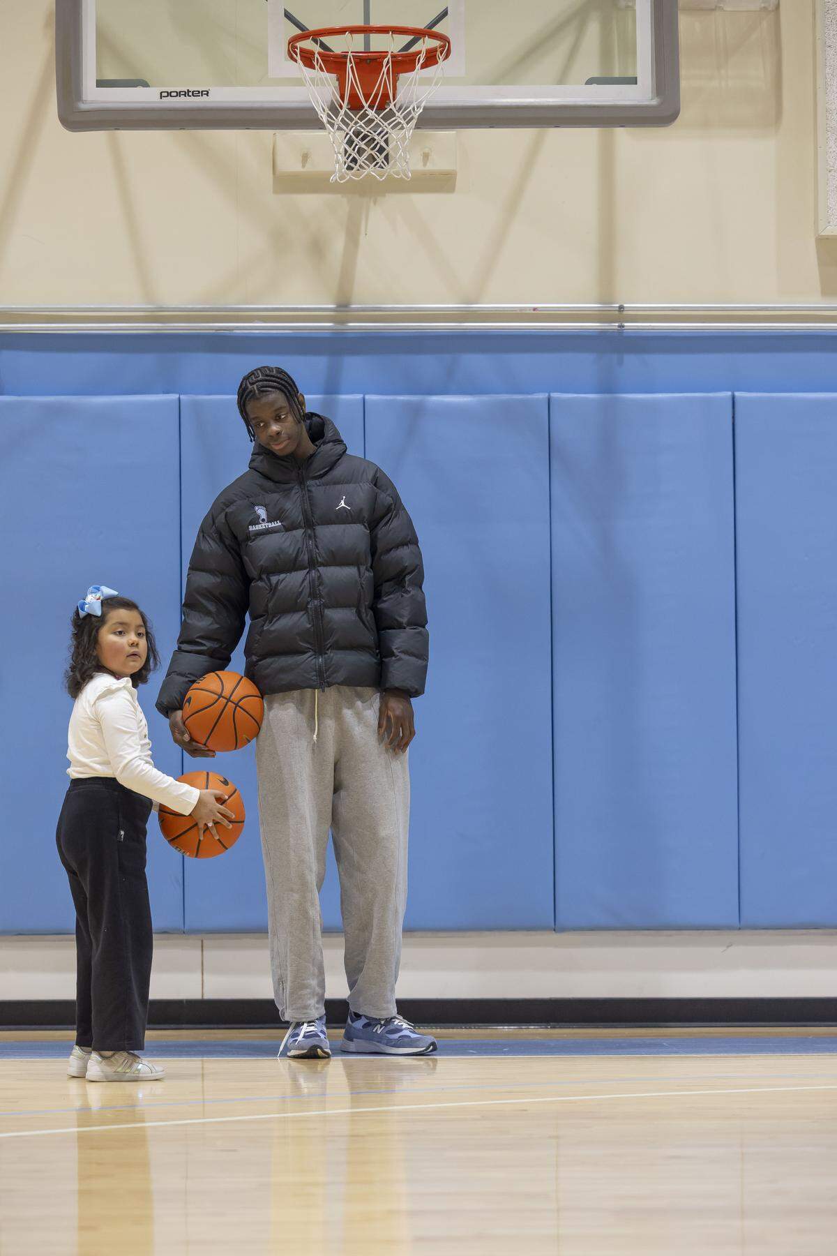 North Carolina forward Caleb Wilson talks with six-year-old Sarah Ramirez of Raleigh, between shooting some hoops, and painting shoes during the Shoes 4 Hope event on Sunday, December 14, 2025 at the Smith Center in Chapel Hill, N.C.