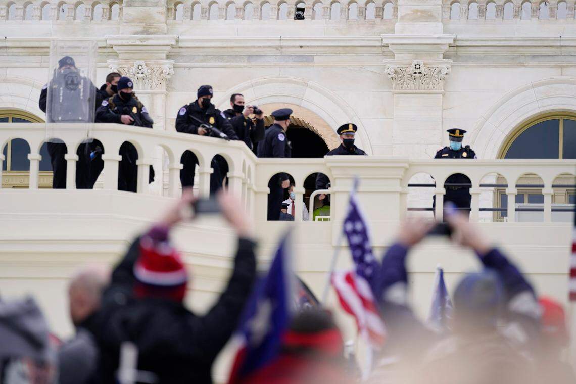 Police keep a watch on demonstrators who tried to break through a police barrier, Wednesday, Jan. 6, 2021, at the Capitol in Washington. As Congress prepares to affirm President-elect Joe Biden’s victory, thousands of people have gathered to show their support for President Donald Trump and his claims of election fraud.