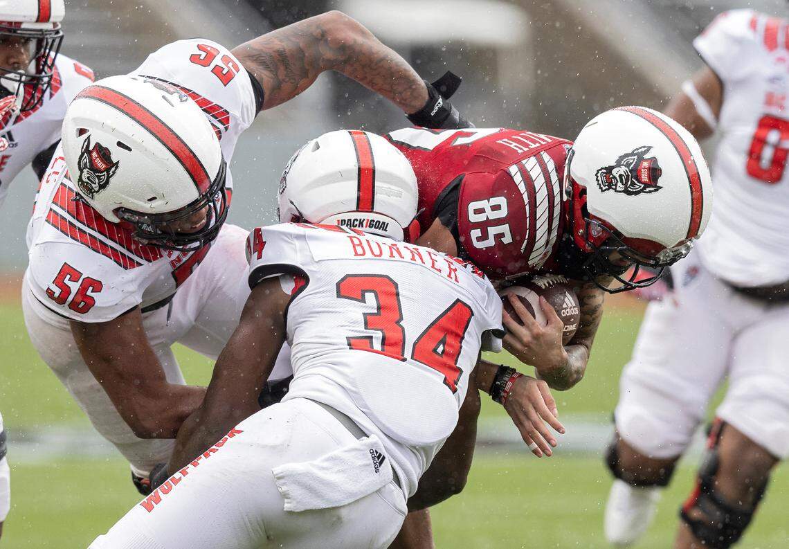 Anthony Smith runs the ball under pressure from Zyun Reeves (56) and Kamal Bonner (34) during N.C. State football’s spring game at Carter-Finley Stadium on Saturday, April 8, 2023, in Raleigh, N.C.