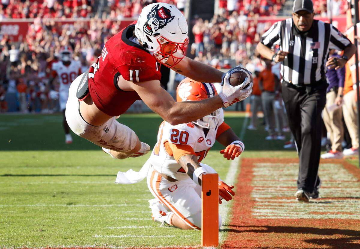 N.C. State linebacker Payton Wilson (11) dives in to score on a 15-yard touchdown interception during the second half of N.C. State’s 24-17 victory over Clemson at Carter-Finley Stadium in Raleigh, N.C., Saturday, Oct. 28, 2023.